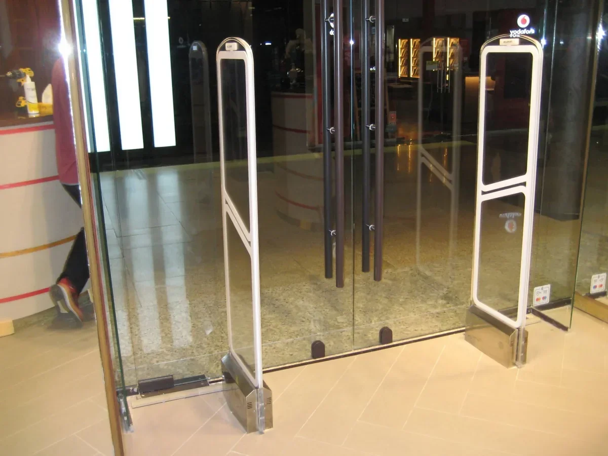 WELLPOINT acrylic anti-theft EAS pedestals at a glass shopping-mall store entrance